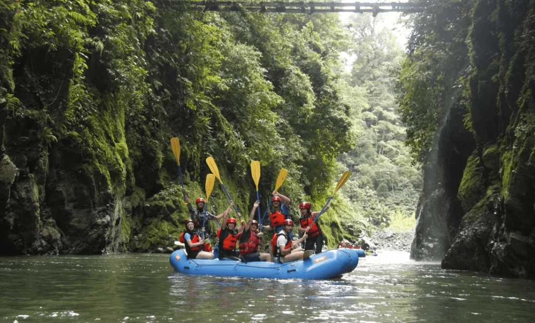 Grupo de turistas haciendo turismo de aventura. Rafting en el Río Pacuare con Explornatura clientes de nuestra consultoría turística en Costa Rica